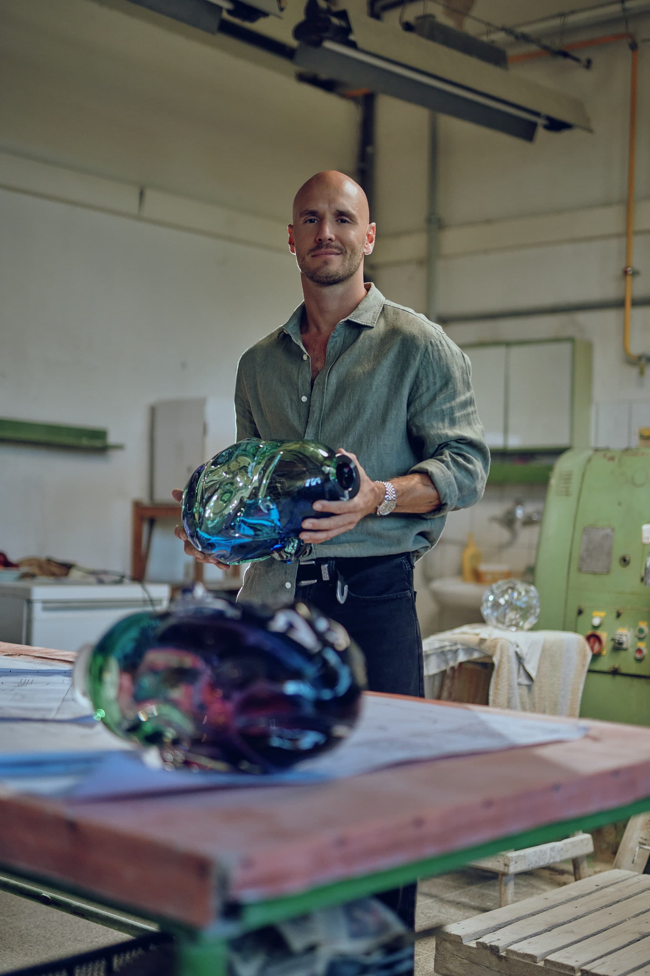 Lukas Čempírek holding a hand-blown glass piece